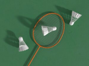 a badminton racket and two shuttles on a green surface
